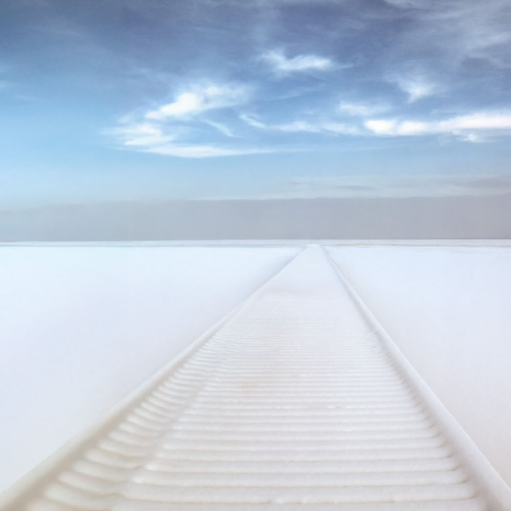 snow covered dock on frozen lake